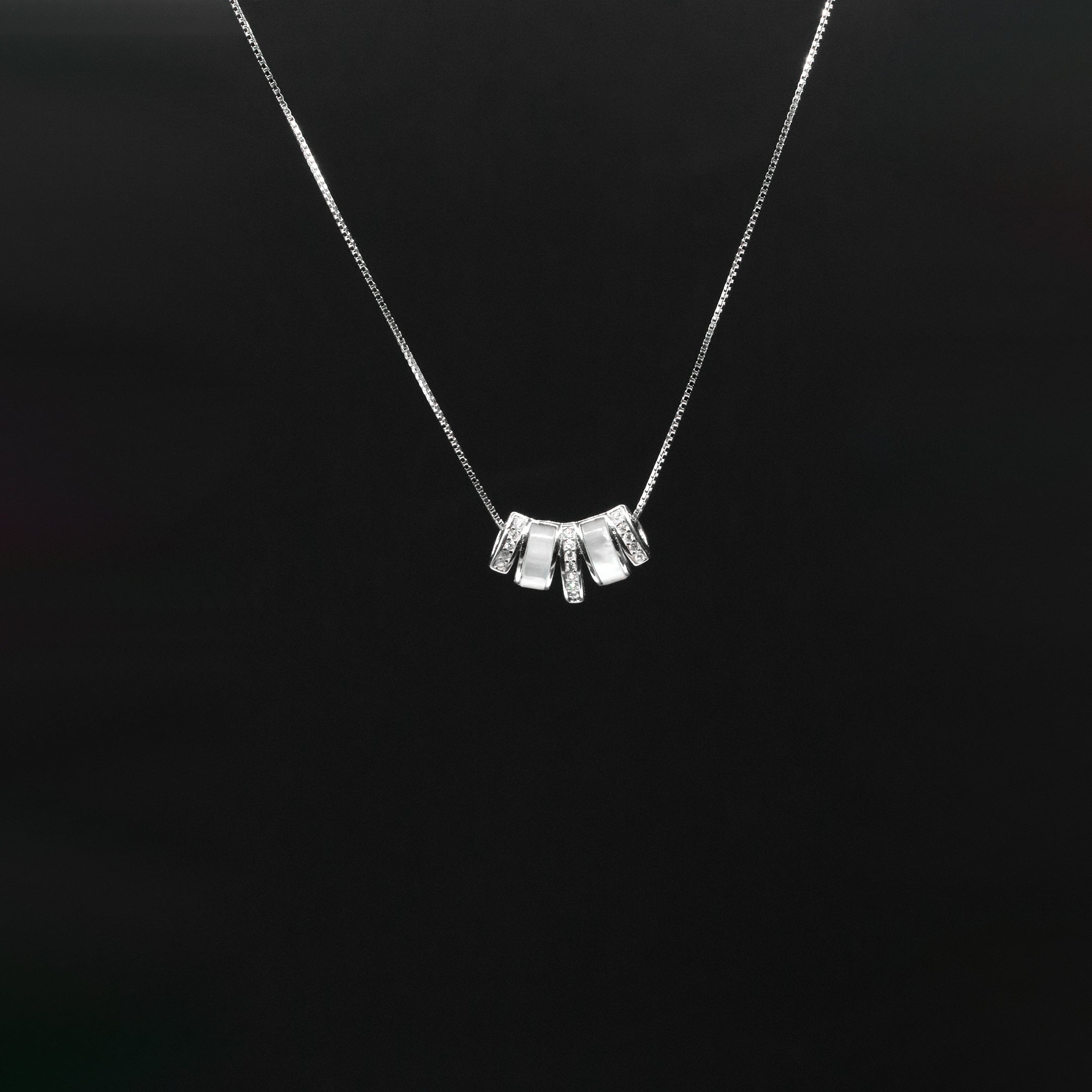 Silver necklace with a unique pendant on a black background