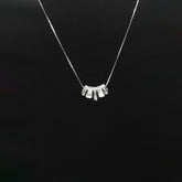 Silver necklace with a unique pendant on a black background