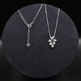 Two silver necklaces on a dark round surface