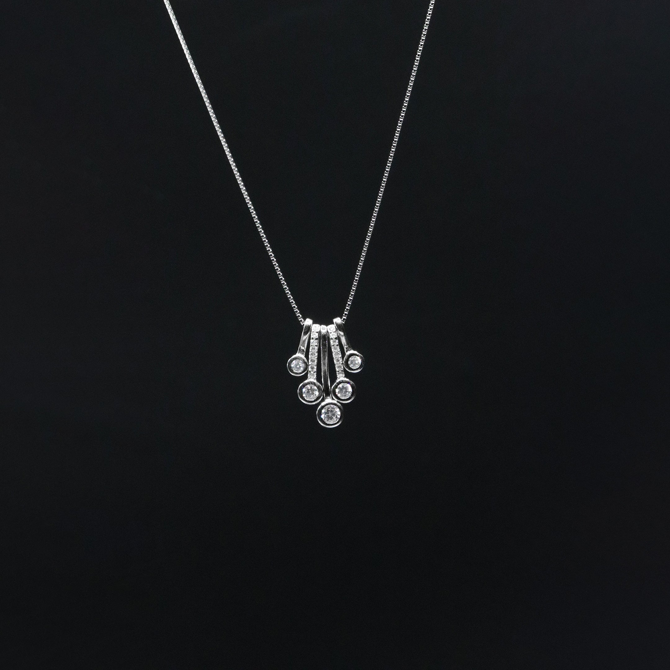 Silver necklace with a pendant on a black background