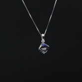 Silver necklace with a square pendant on a black background