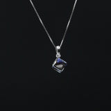 Silver necklace with a square pendant on a black background
