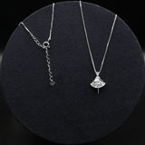 Two silver necklaces on a black textured surface