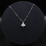 Silver necklace with a fan-shaped pendant on a black textured surface