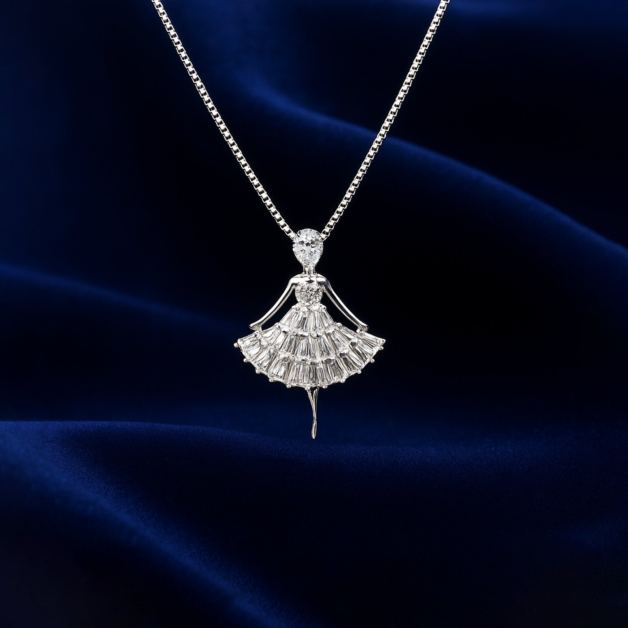 Diamond necklace with a fan-shaped pendant on a dark blue fabric background