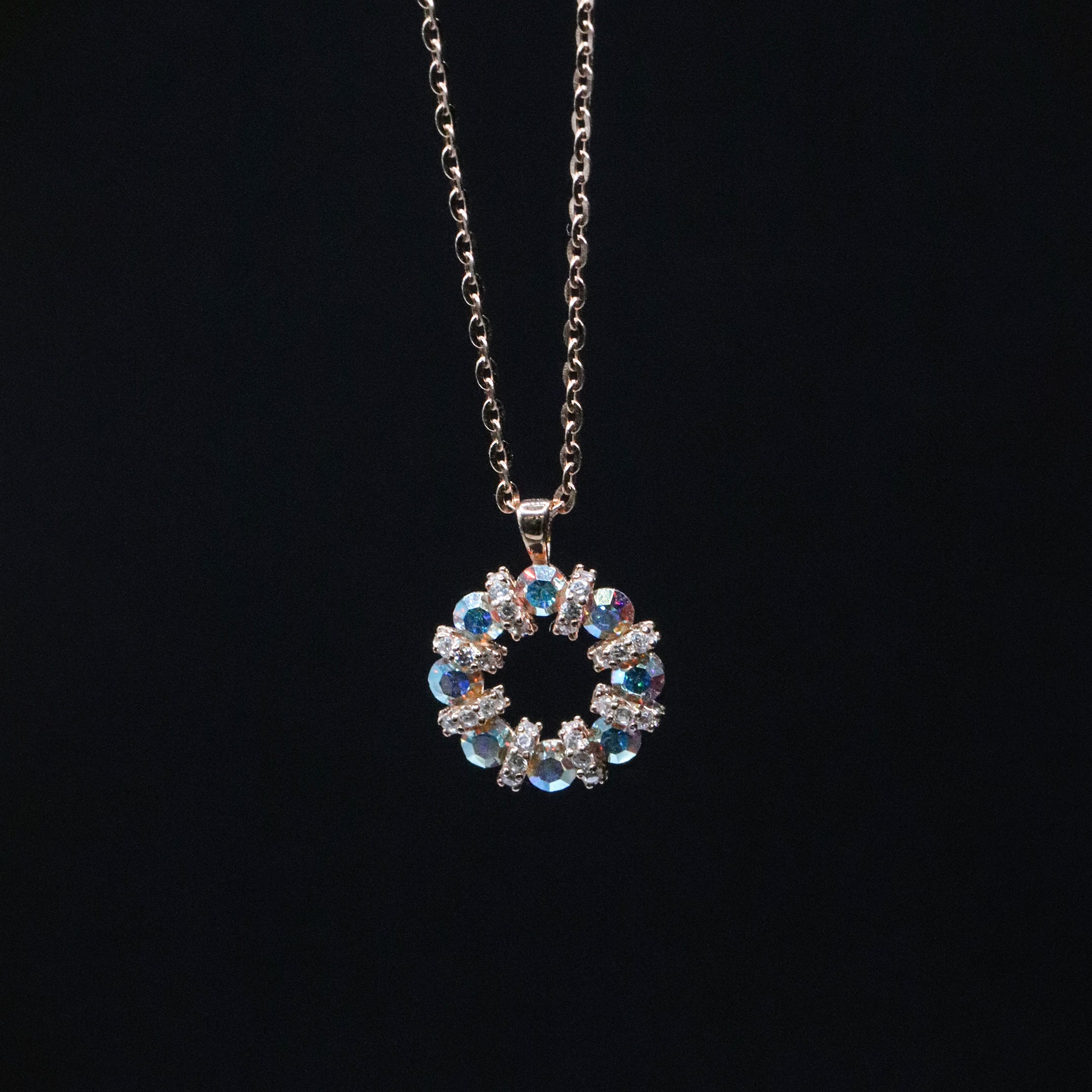 Necklace with a circular pendant featuring blue and clear stones on a black background