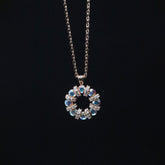 Necklace with a circular pendant featuring blue and clear stones on a black background