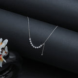 Silver necklace with crystals on a dark surface