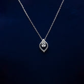 Silver necklace with a teardrop-shaped pendant on a dark blue background