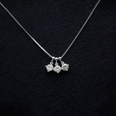 Silver necklace with three pendant drops on a black textured background