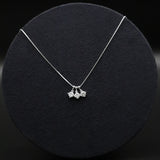 Silver necklace with three pendant drops on a black background
