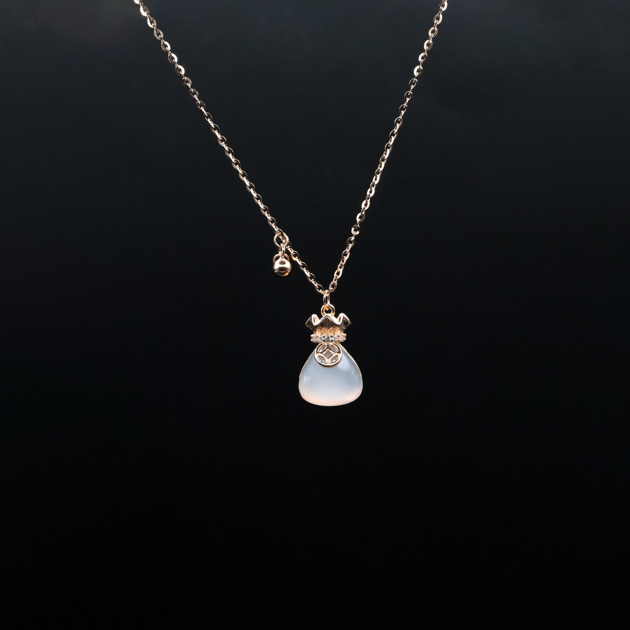 Necklace with a blue teardrop pendant on a black background