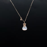 Necklace with a blue teardrop pendant on a black background