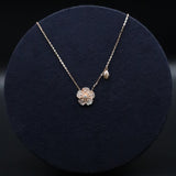 Necklace with a floral pendant on a dark blue velvet stand