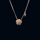 Gold flower-shaped necklace on a black background