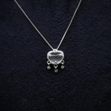Silver necklace with a heart-shaped pendant on a dark textured background