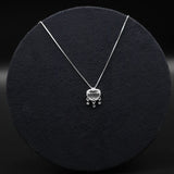 Silver necklace with a heart-shaped pendant on a black background