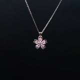Flower-shaped pink gemstone necklace on a black background