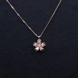 Necklace with a pink flower pendant on a dark background