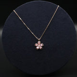 Necklace with a floral pendant on a dark circular stand