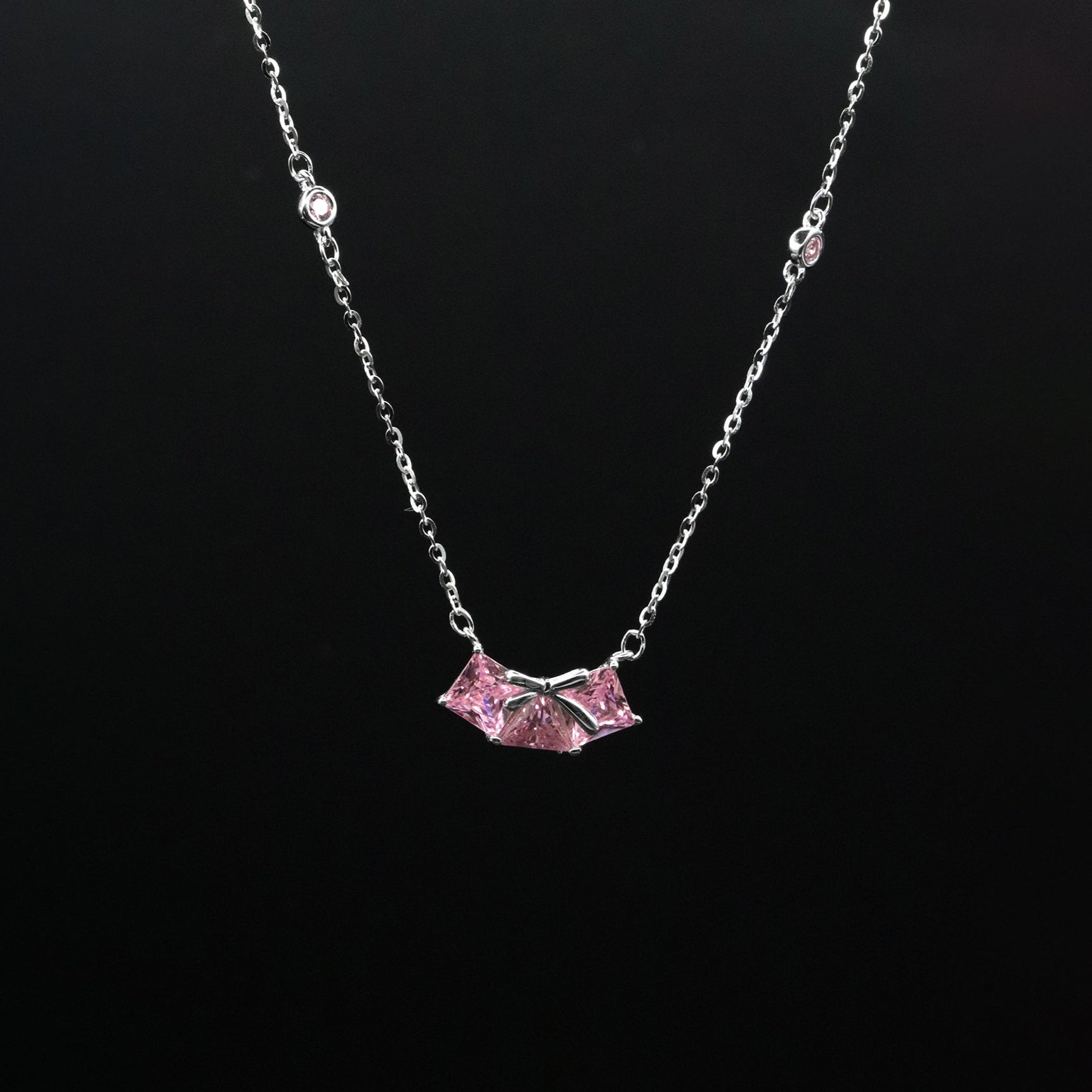 Necklace with a pink pendant on a black background