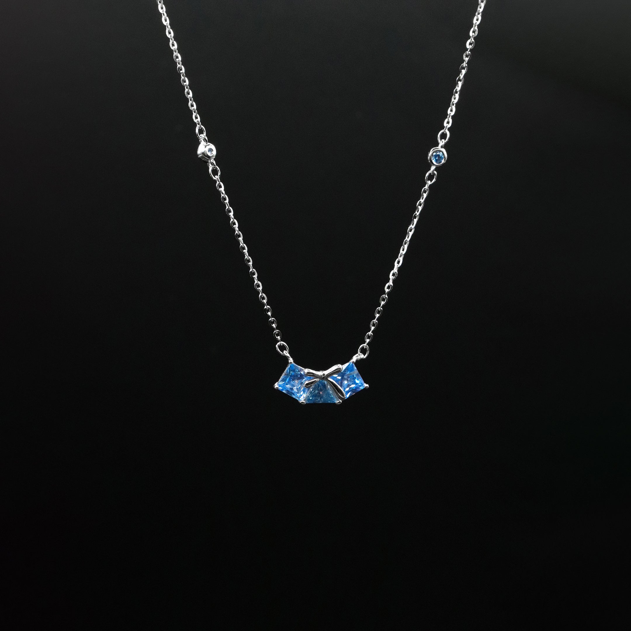 Necklace with a blue pendant on a black background