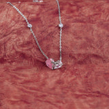 Necklace with a pink pendant on a red textured background