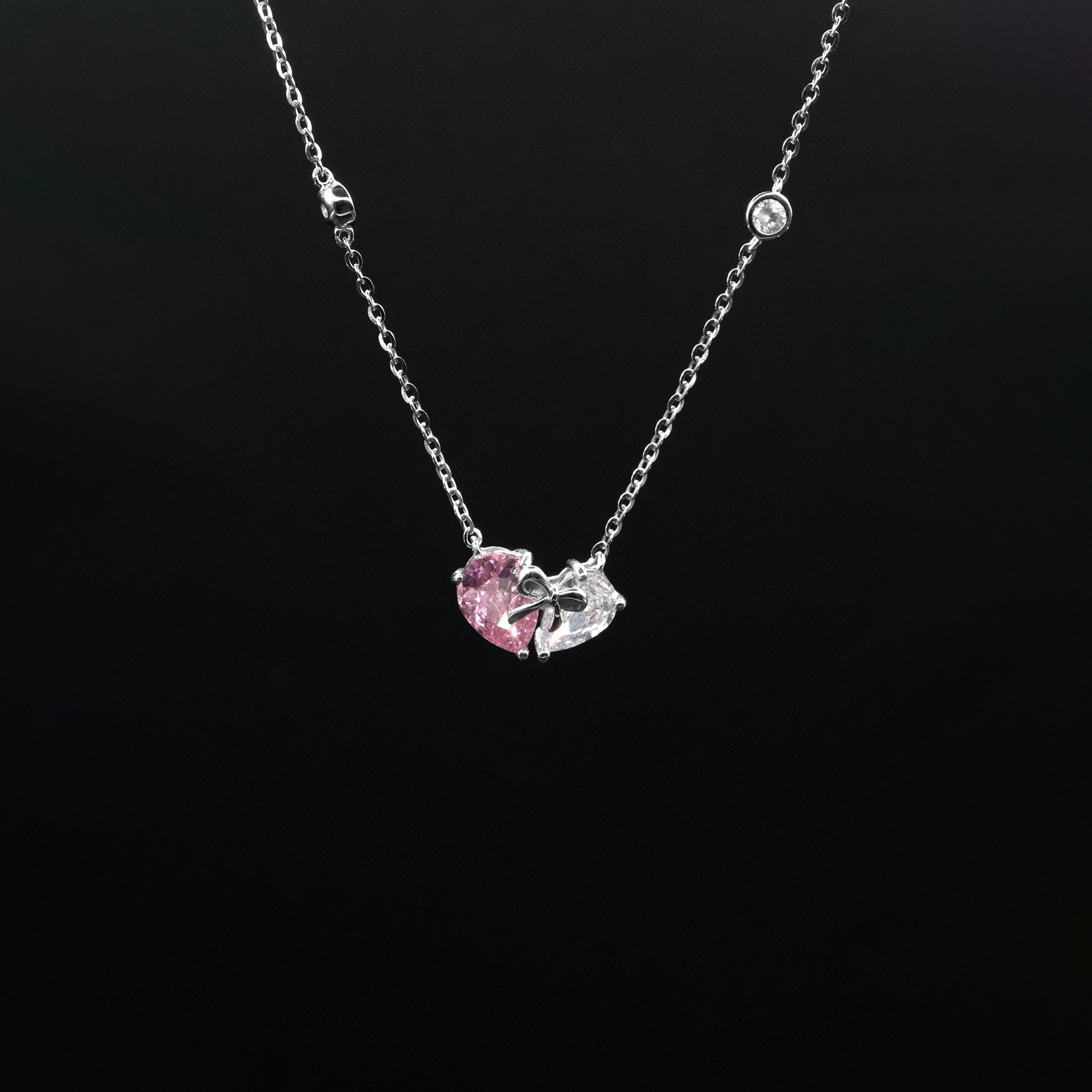 Necklace with a pink heart-shaped pendant on a black background