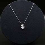 Silver necklace with a pendant on a black textured surface