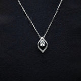 Silver necklace with a teardrop-shaped pendant on a black background