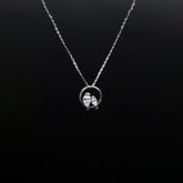Silver necklace with a pendant on a black background