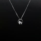 Silver necklace with a pendant on a black background