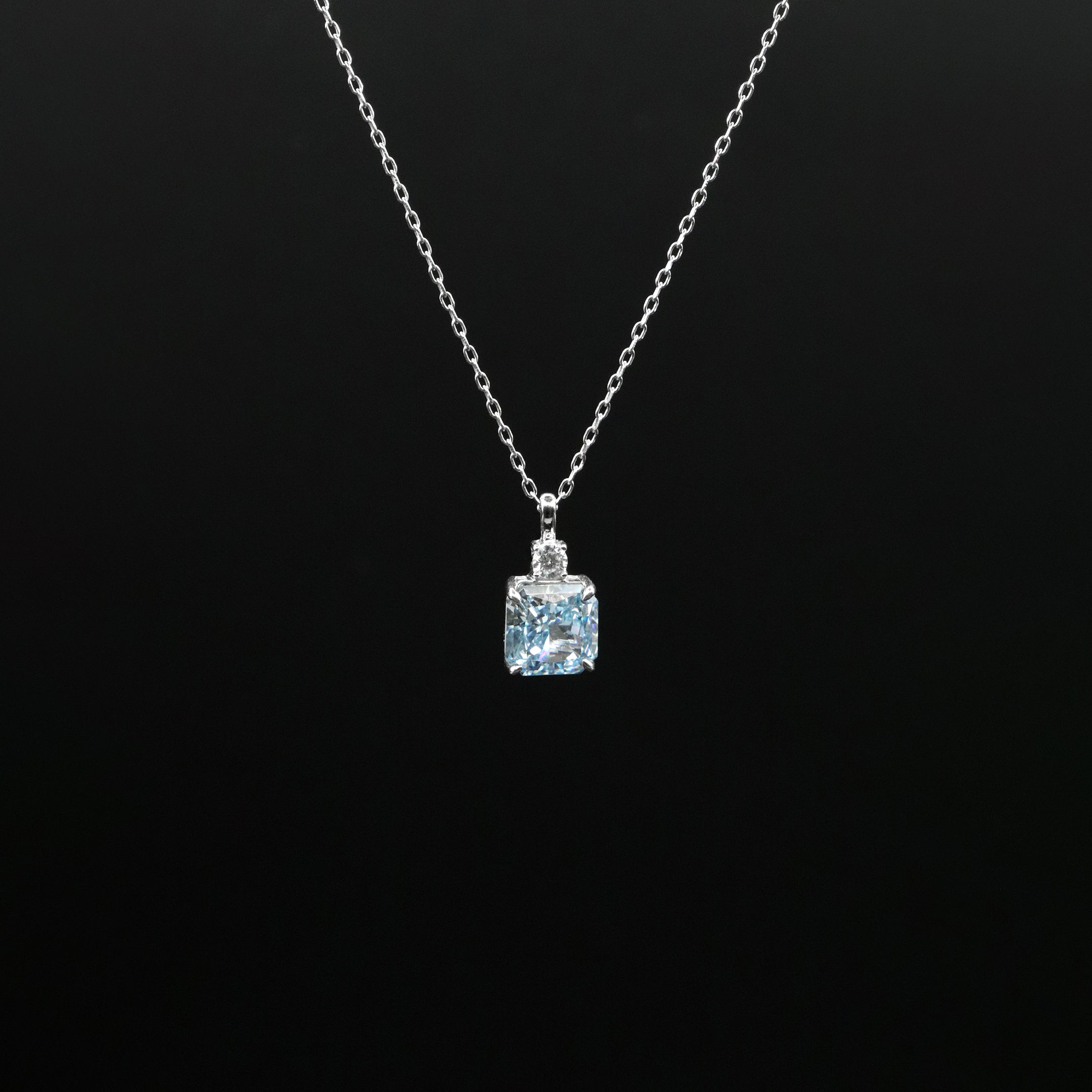 Necklace with a pendant featuring a blue gemstone on a black background