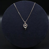 Silver necklace with a pendant on a dark blue cushion