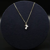 Gold necklace with a pendant on a black round cushion