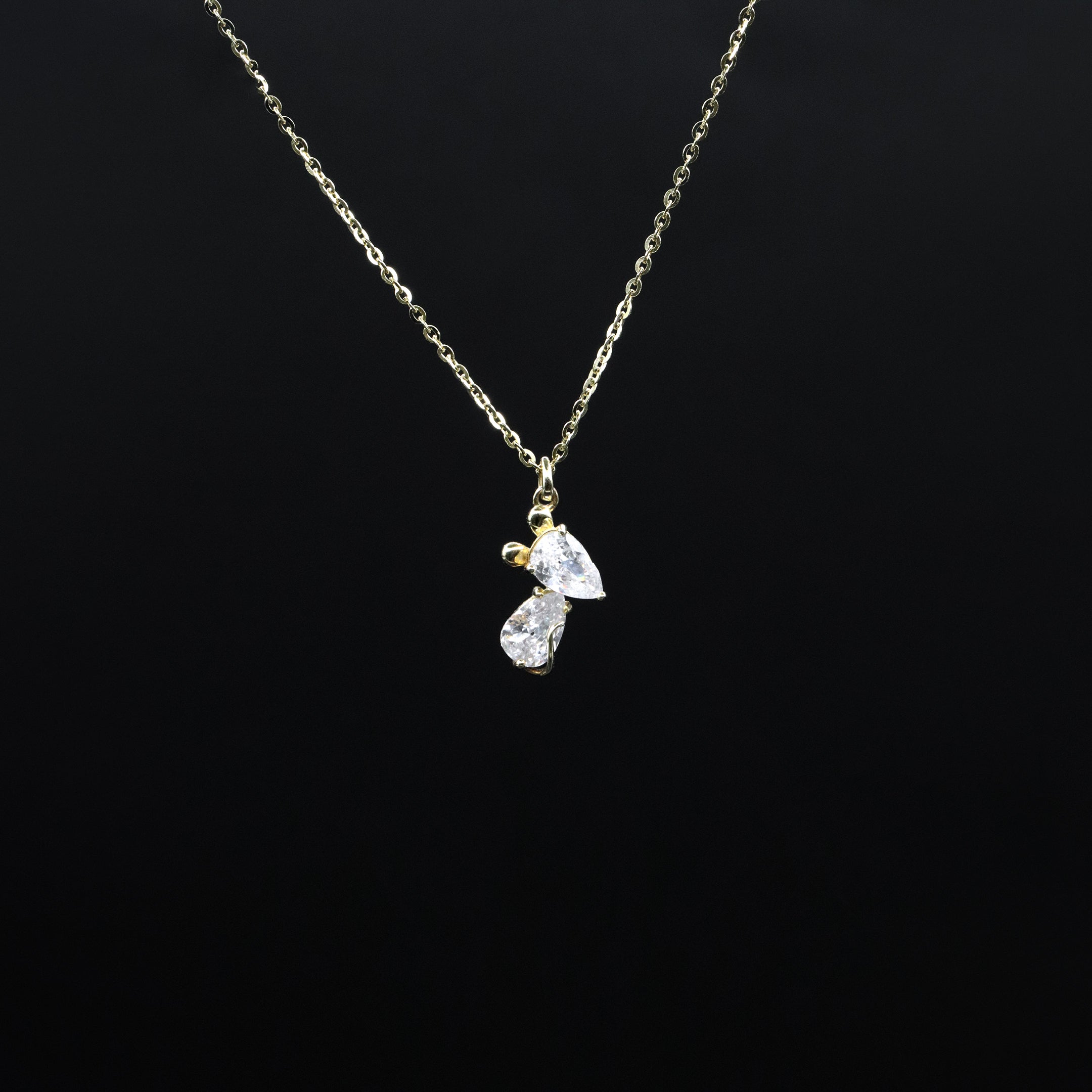 Gold necklace with a diamond pendant on a black background