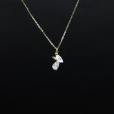 Gold necklace with a diamond pendant on a black background