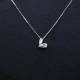 Silver necklace with a heart-shaped pendant on a dark background