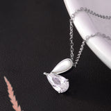 Silver necklace with a teardrop-shaped pendant on a dark background