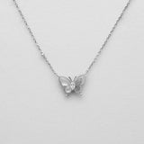 Butterfly pendant necklace on a light gray background