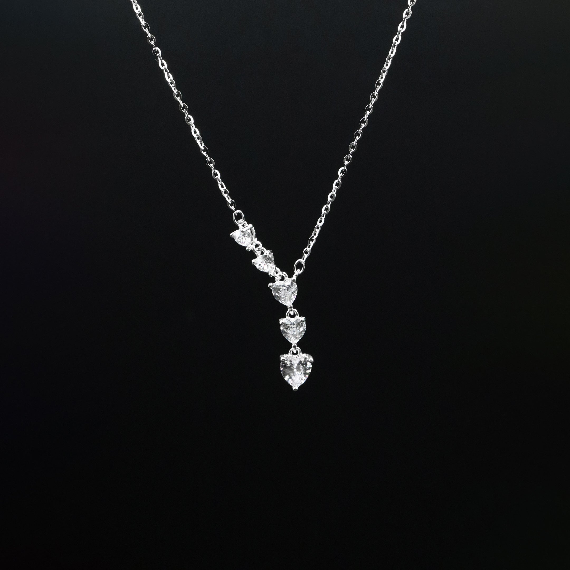 Silver necklace with a pendant on a black background