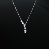 Silver necklace with a heart-shaped pendant on a black background