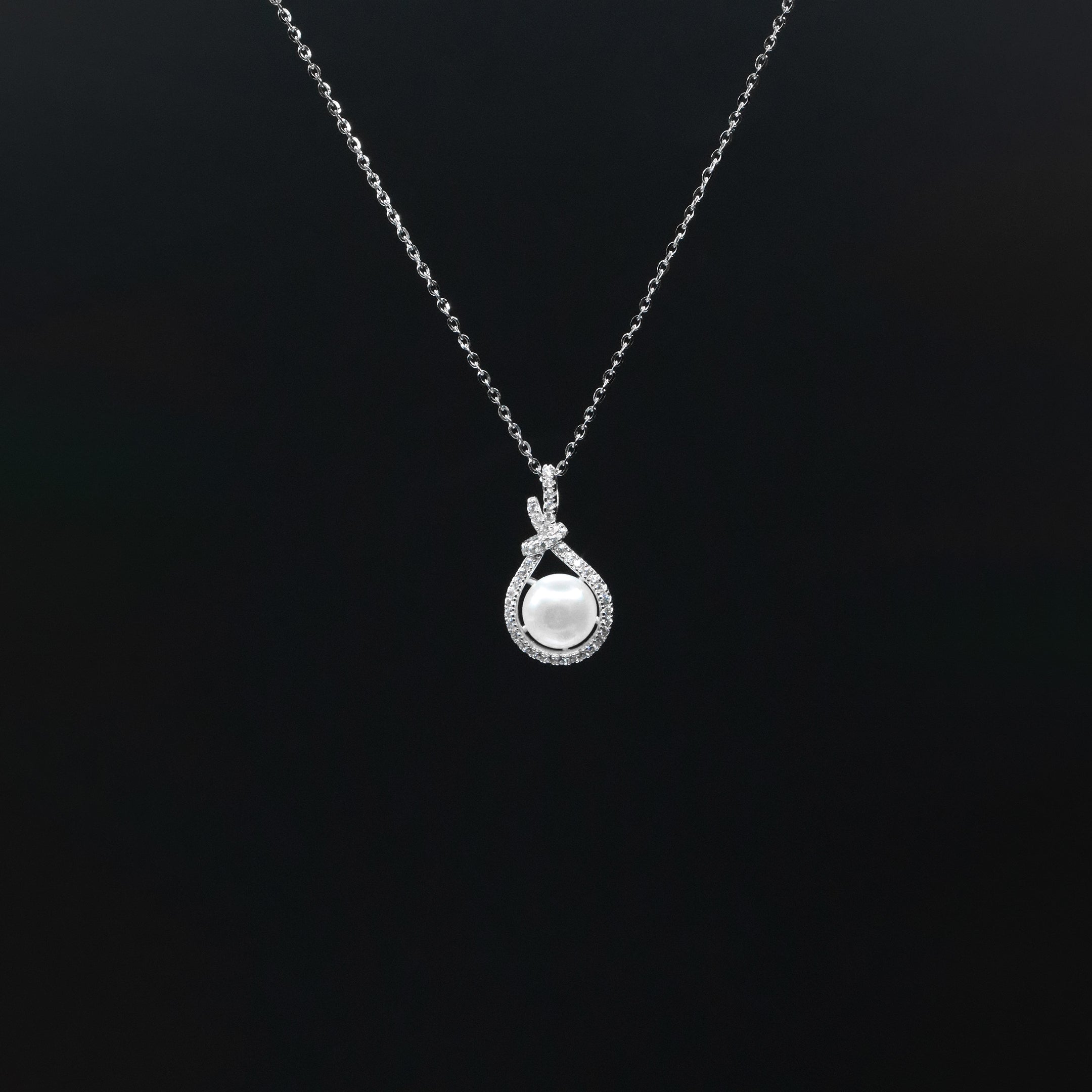 Silver necklace with a pendant on a black background