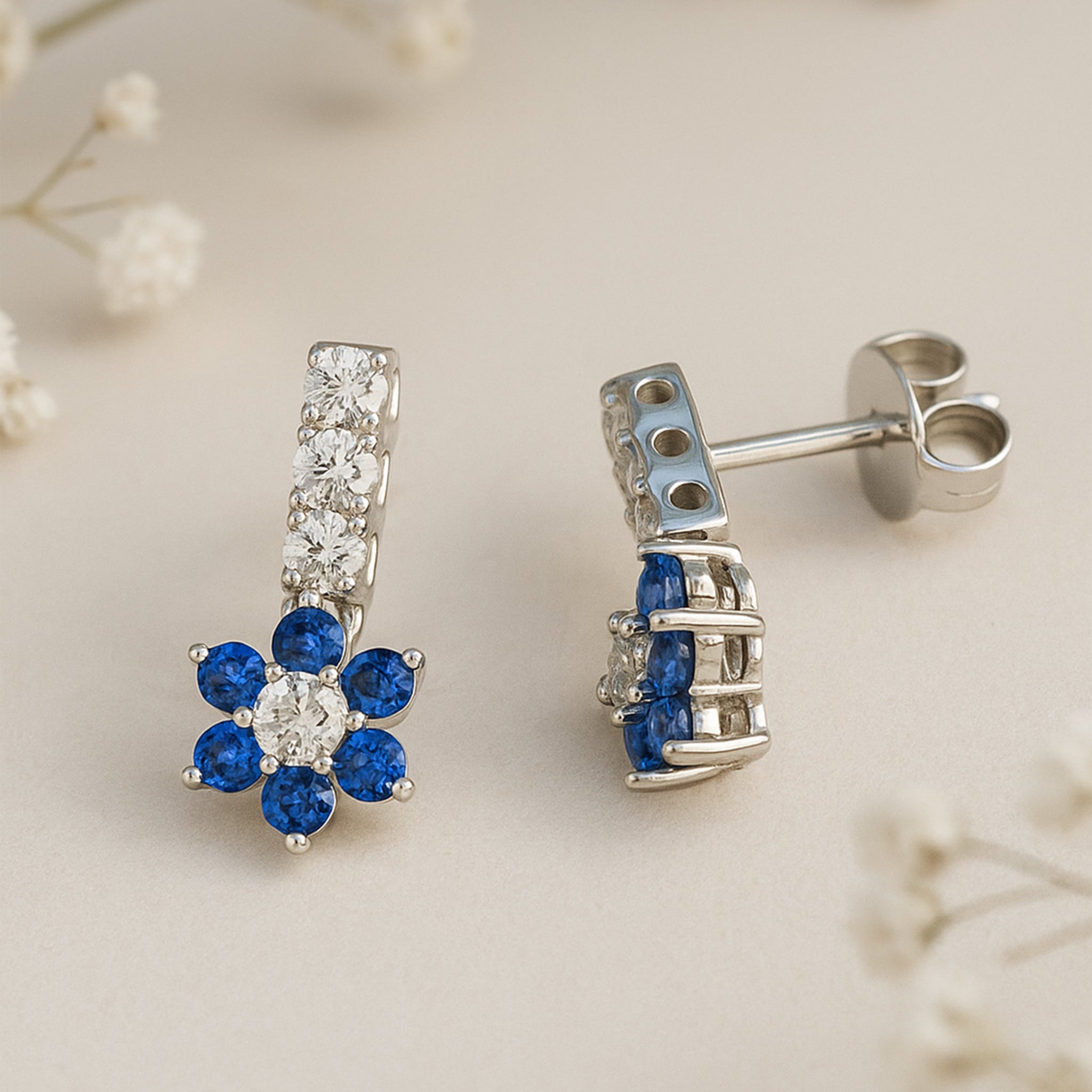 Silver earrings with blue gemstones on a light background