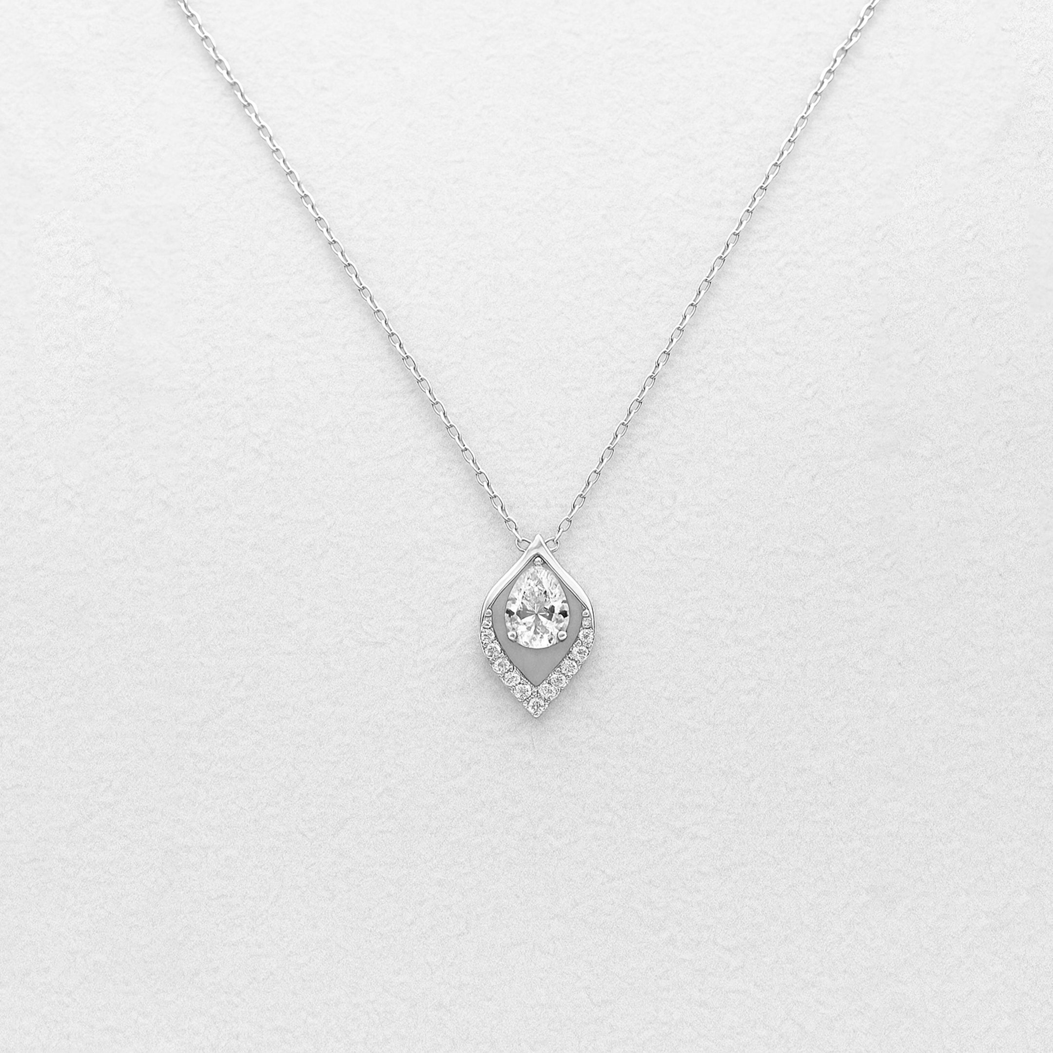 Silver necklace with a teardrop-shaped pendant on a light gray background