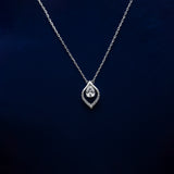 Silver necklace with a teardrop-shaped pendant on a dark blue background