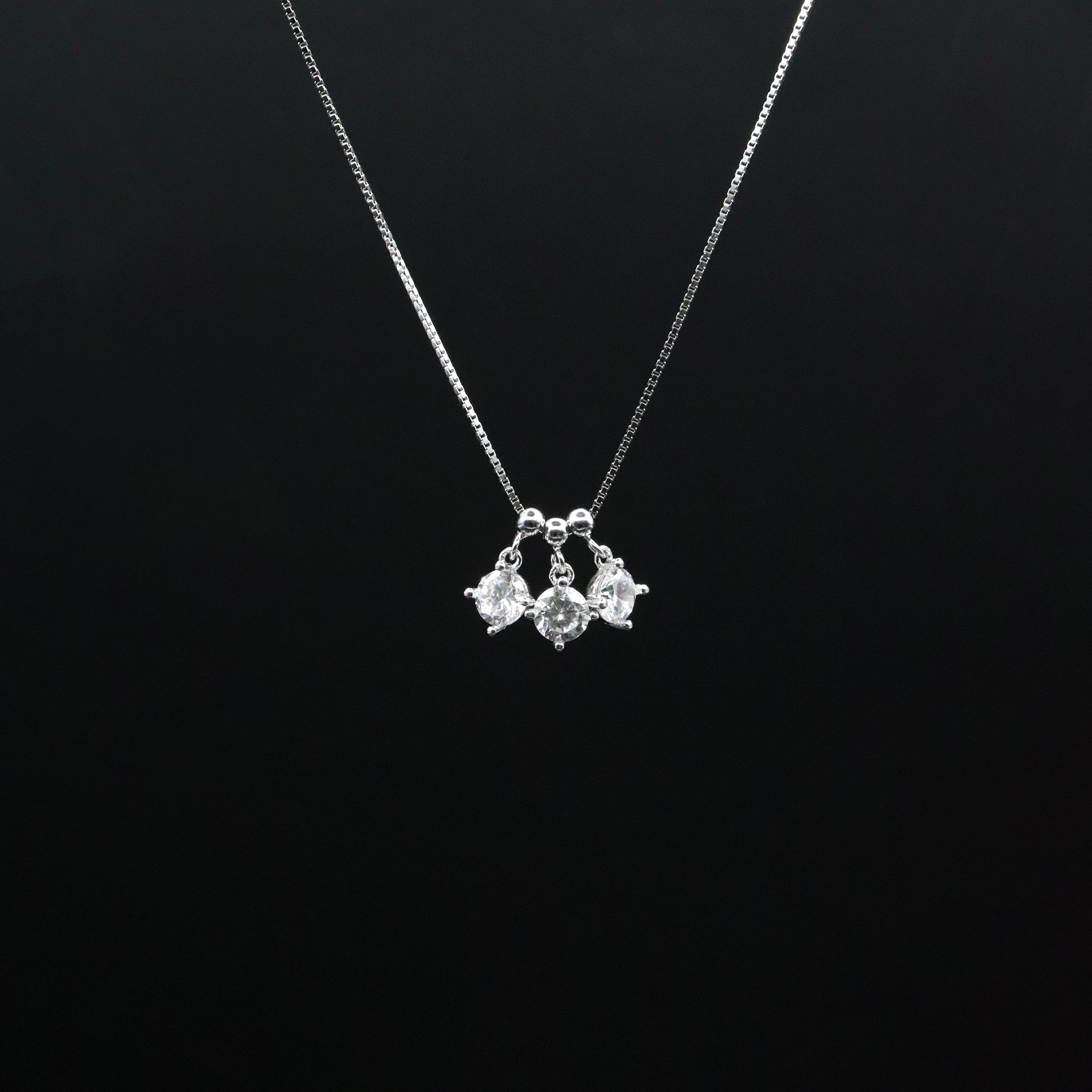 Silver necklace with a pendant on a black background