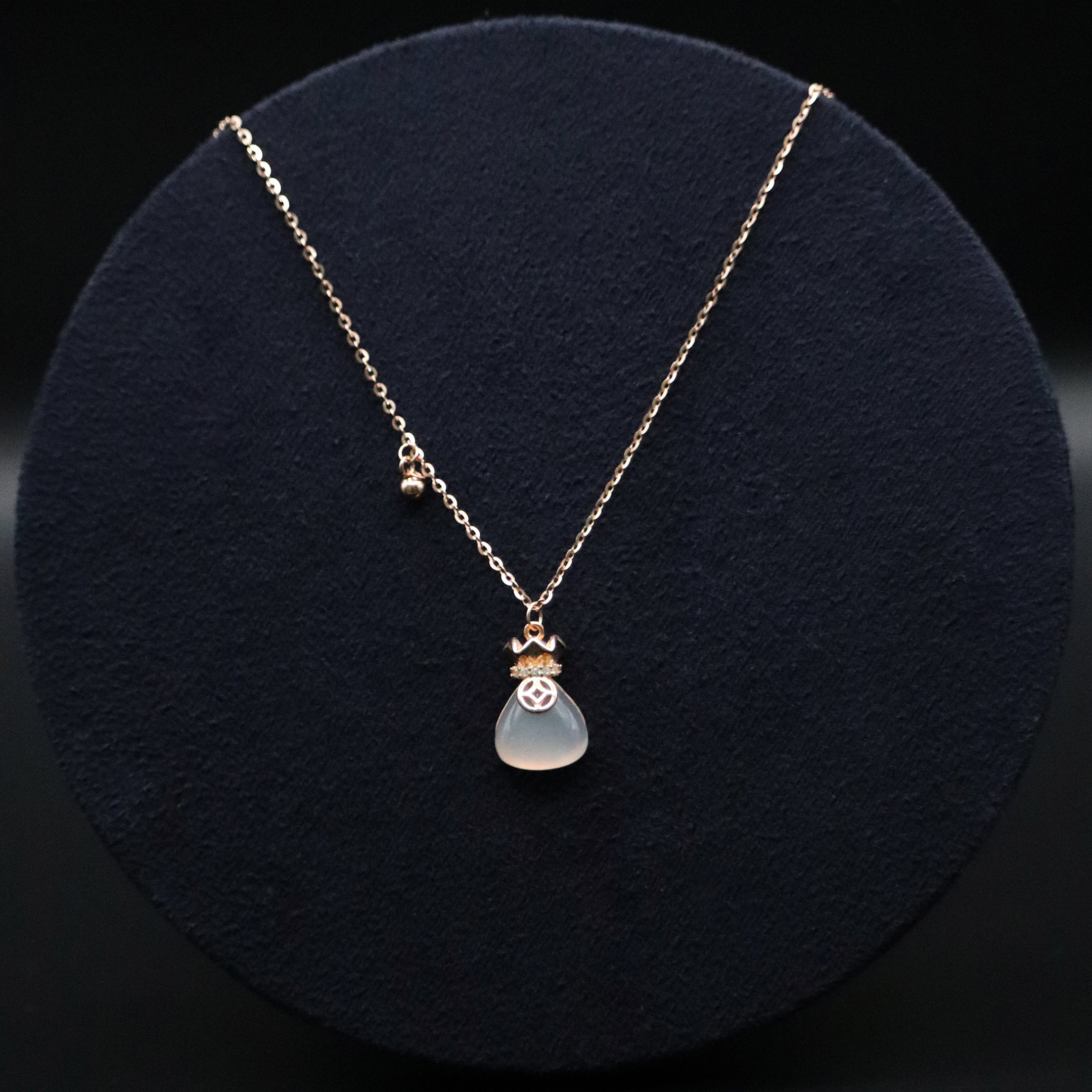 Necklace with a pendant on a dark round cushion