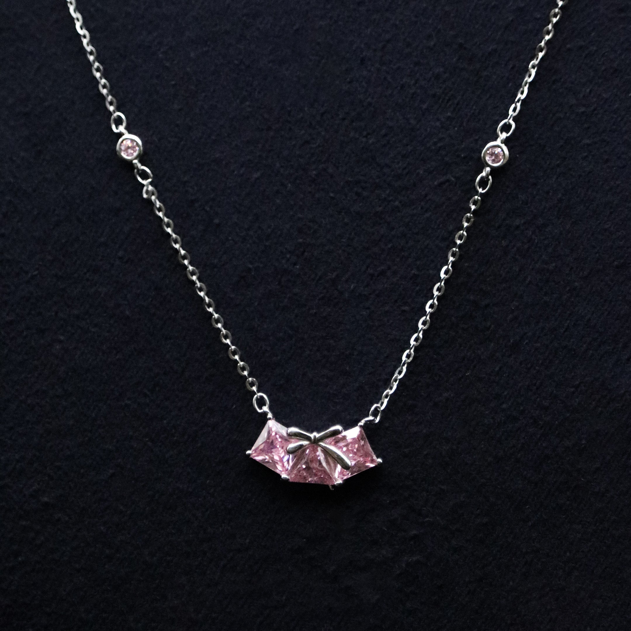 Necklace with a pink pendant on a black background