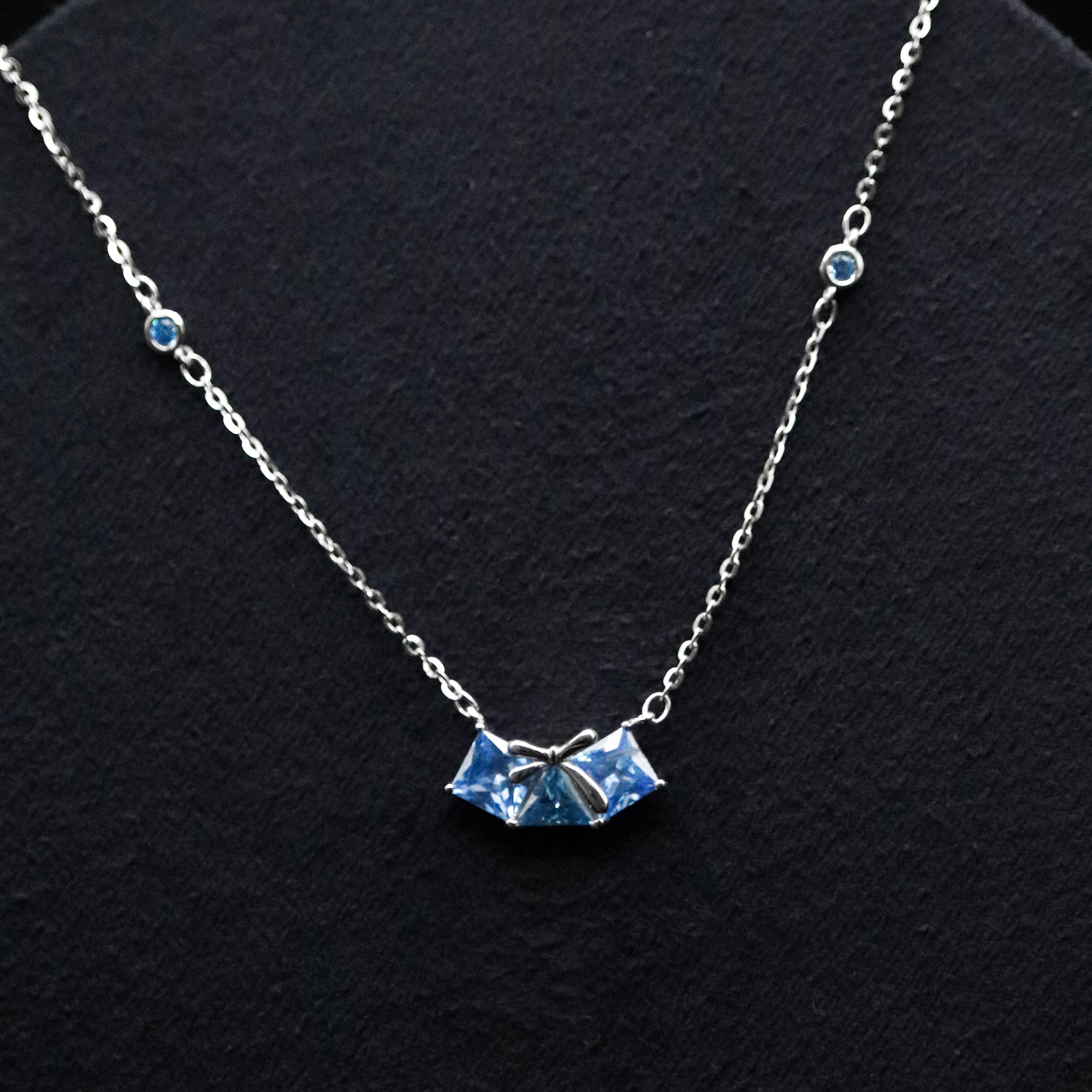Necklace with a blue pendant on a black background